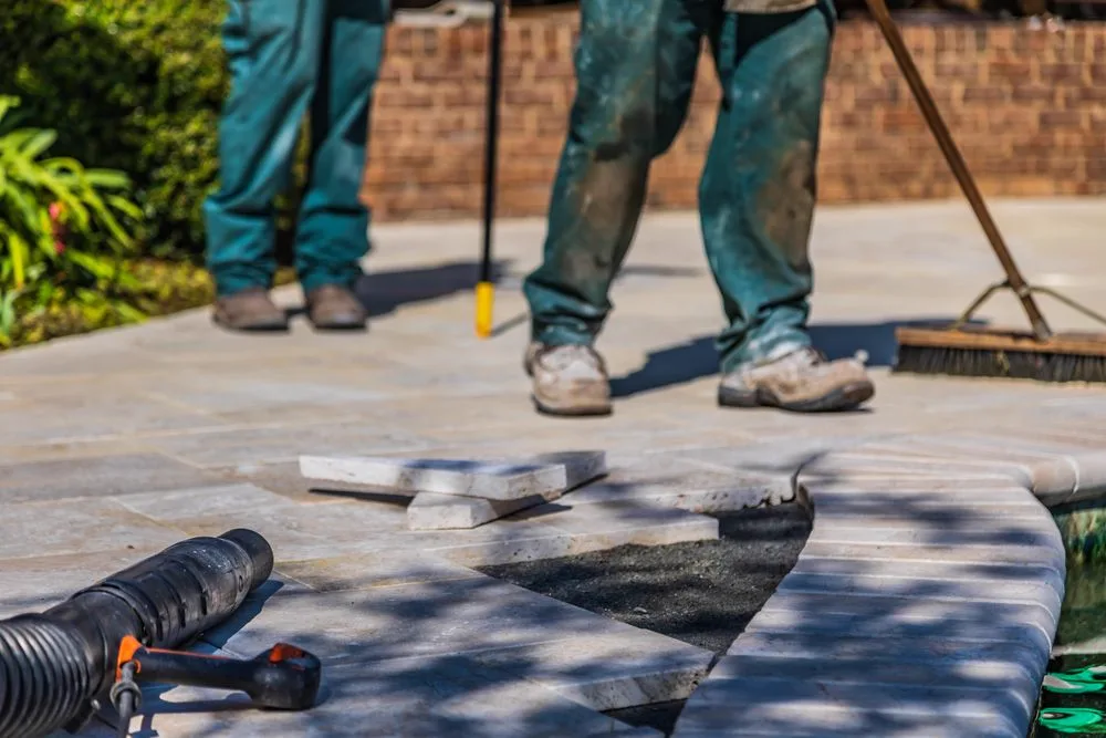 Workers laying paving on an outdoor patio